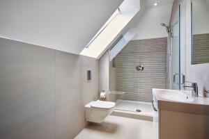 梅登黑德Imperial Court By Viridian Apartments的浴室配有卫生间、水槽和天窗。