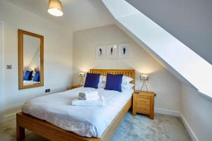 梅登黑德Imperial Court By Viridian Apartments的一间卧室配有一张带蓝色枕头和镜子的床