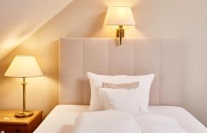 慕尼黑弗瑞森格酒店的卧室配有带两盏灯的白色床