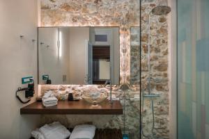干尼亚大使官邸精品酒店的浴室配有盥洗盆和带镜子的淋浴