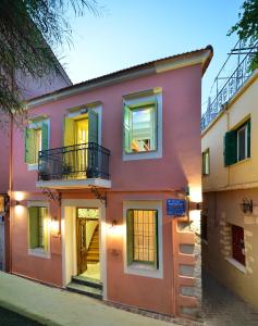 干尼亚Casa della Favola Boutique Hotel的粉红色的房子,在街上设有阳台
