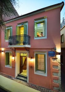 干尼亚Casa della Favola Boutique Hotel的粉红色的房子,在街上设有阳台