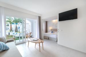 卡兰博希Carema Beach Menorca的酒店客房设有床和客厅。