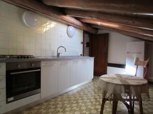 巴塞尔加·迪·皮纳Casa Margherita的厨房配有白色橱柜、水槽和桌子