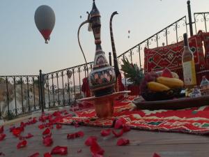 格雷梅米拉特窑洞酒店的一张桌子,上面有红色玫瑰花瓣,地面上有一个热气球