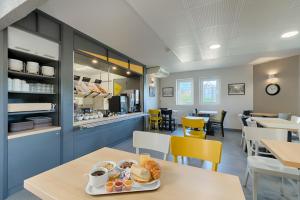 马赛B&B HOTEL Marseille Estaque的早餐室配有一张带一盘食物的桌子