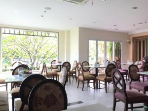 乌隆他尼乌隆他尼基特拉达酒店的用餐室设有桌椅和窗户。