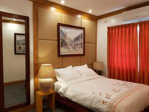 麦克坦Stay Amare Pacific Grand Magnolia的一间卧室配有床和红色窗帘
