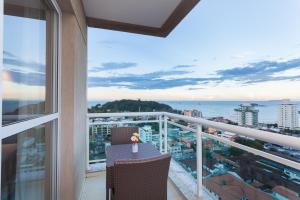 马卡埃Ramada by Wyndham Macae Hotel & Suites的阳台配有桌子,享有海景。