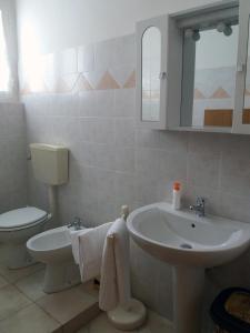 乌尔巴尼亚Appartamento Casteldurante的白色的浴室设有水槽和卫生间。
