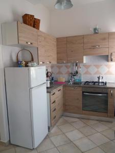 乌尔巴尼亚Appartamento Casteldurante的厨房配有白色冰箱和木制橱柜。