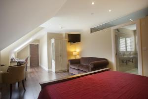 戈尔韦Sea Breeze Lodge B&B Galway的一间卧室配有一张床、一把椅子和一张沙发