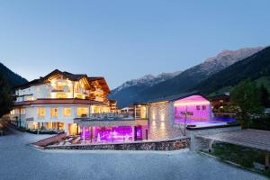 施图拜河谷新施蒂夫特Premium Activehotel Bergkönig的一座大房子,上面有紫色的灯