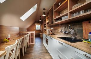 班斯卡 - 什佳夫尼察Sad nad Klingerom的厨房铺有木地板,配有白色橱柜。