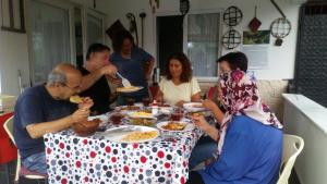 BalçıklıEkolojik Güney Köy Pembe Köşk的一群坐在桌子旁吃食物的人
