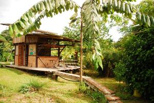 莫姆皮切Maracumbo Lodge的一座小木结构建筑,在田野上设有门廊