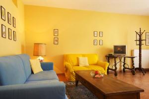 韦尔巴尼亚Appartamento Le Rose的客厅设有蓝色的沙发和黄色的墙壁