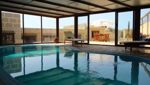 La DegolladaCasa en finca de uva con piscina privada, cubierta y climatizada的一个带椅子和桌子的游泳池