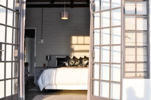 AugrabiesAvonsrus Guesthouse的一间卧室配有带白色床单和枕头的床。