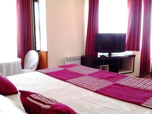 奥瓦列Gran Hotel Ovalle的一间卧室配有一张床铺,床上铺有紫色毯子