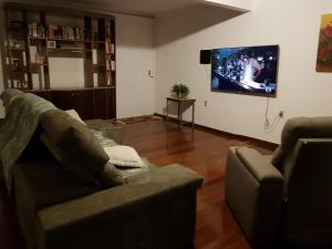 乌贝兰迪亚Casa da Lúcia的带沙发和平面电视的客厅