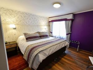 维纳德马LV Hoteles Boutique的一间卧室配有一张大床和紫色墙壁