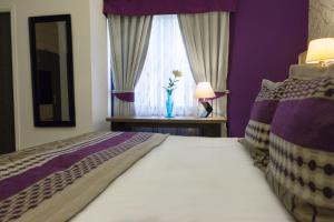 维纳德马LV Hoteles Boutique的一间卧室配有一张紫色墙壁和窗户的床