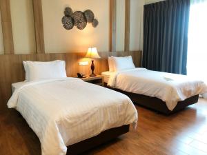 乌隆他尼Civilize Hotel的酒店客房设有两张床和窗户。
