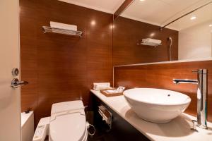 松本松本丸之内酒店的浴室配有白色水槽和卫生间。