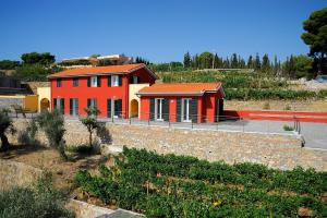 迪亚诺马里纳波焦代格力农家乐的山坡上一座红色房子,屋顶橙色