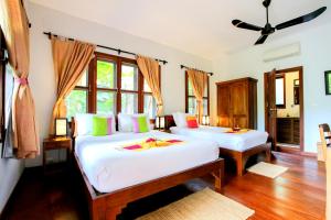 马德望梅森韩寺酒店的一间卧室设有两张床和窗户。