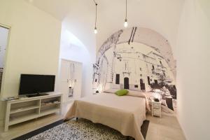 马丁纳弗兰卡da Nonna Lata的一间卧室配有一张床,并在一间客房内配有电视。
