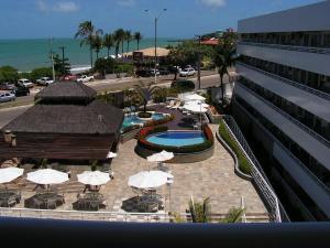 帕纳米林Blue Marlin Resort&Spa的一个带遮阳伞的庭院、一个游泳池和一座建筑