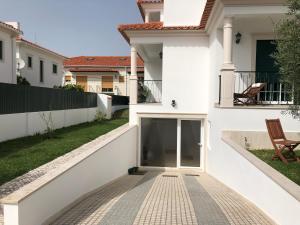 纳扎雷alojamento Xa andar的带阳台和步道的白色房屋