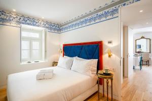 里斯本奥莱亚公寓的一间卧室配有一张大床和蓝色床头板