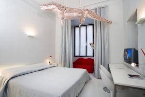 都灵波士顿艺术酒店的卧室配有白色的床和红色椅子