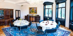 Jevany维拉奥尔加酒店的一间带2张桌子和椅子的用餐室以及吊灯