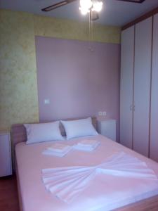 拉斐那Rafina Port Paradise的卧室配有白色的床和2条毛巾