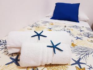 圣维托罗卡波Guest House San Vito Lo Capo的一张带毛巾和蓝色枕头的床