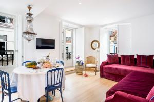里斯本奥莱亚公寓的客厅配有桌子和红色沙发