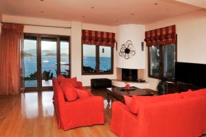 斯基亚索斯镇Poseidon villa m ammos的客厅配有红色椅子和电视