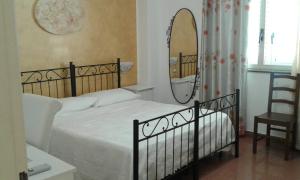 富尔奇西库洛S.安东尼奥西尔维娅餐厅旅馆的一间卧室配有一张带镜子和椅子的床