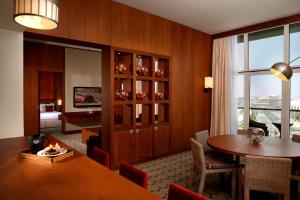 阿布扎比阿布扎比亚斯岛罗塔纳酒店的一间带桌子的用餐室和一间带卧室的房间