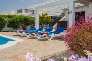 普拉亚布兰卡苏萨埃塔别墅酒店的游泳池旁的一排蓝色躺椅