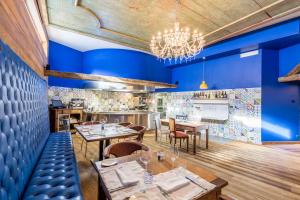 布勒伊-切尔维尼亚Aux Pieds du Roi - Suite & Spa的餐厅拥有蓝色的墙壁和桌椅