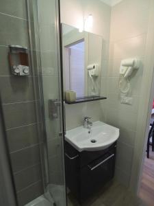 那不勒斯Bella Vita Rooms的浴室配有盥洗盆和带镜子的淋浴