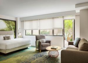 纽约The Gardens Sonesta ES Suites New York的一间卧室配有一张床、一张沙发和一张桌子