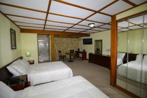 圣何塞图尔农别墅酒店的一间卧室配有两张床和一张书桌及电视