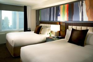 纽约The Fifty Sonesta Hotel New York的酒店客房设有两张床和大窗户。