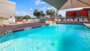 圣安东尼奥Travelodge by Wyndham San Antonio Downtown Northeast的一座蓝色海水和椅子的游泳池,一座建筑